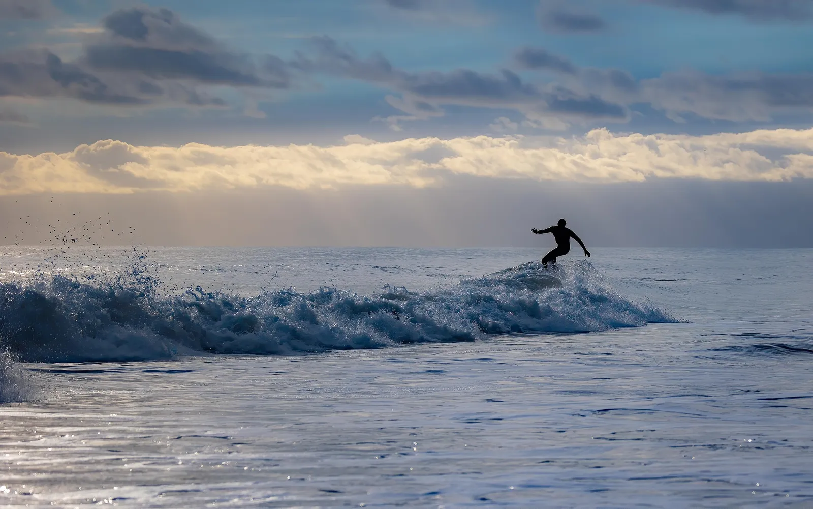 Surfer on a wave in the evening light